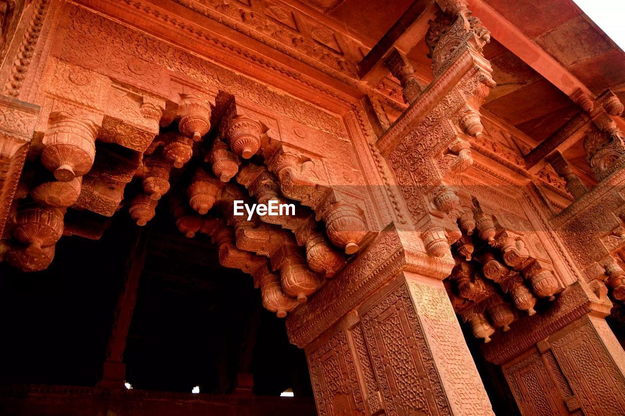 LOW ANGLE VIEW OF CARVINGS ON WALL OF BUILDING