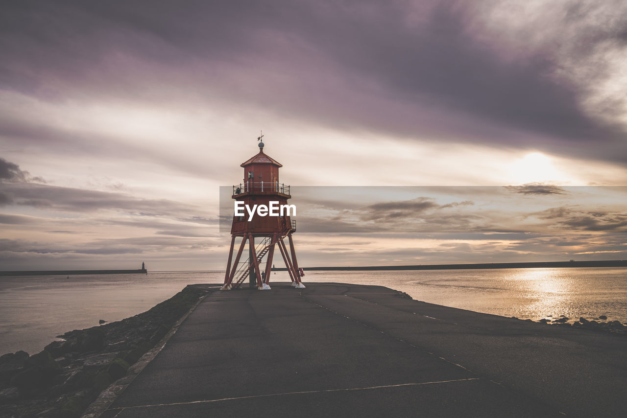 scenic view of beach against cloudy sky during sunset