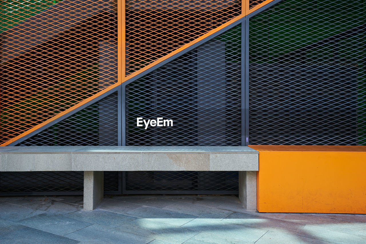 Metal fence against orange wall of building