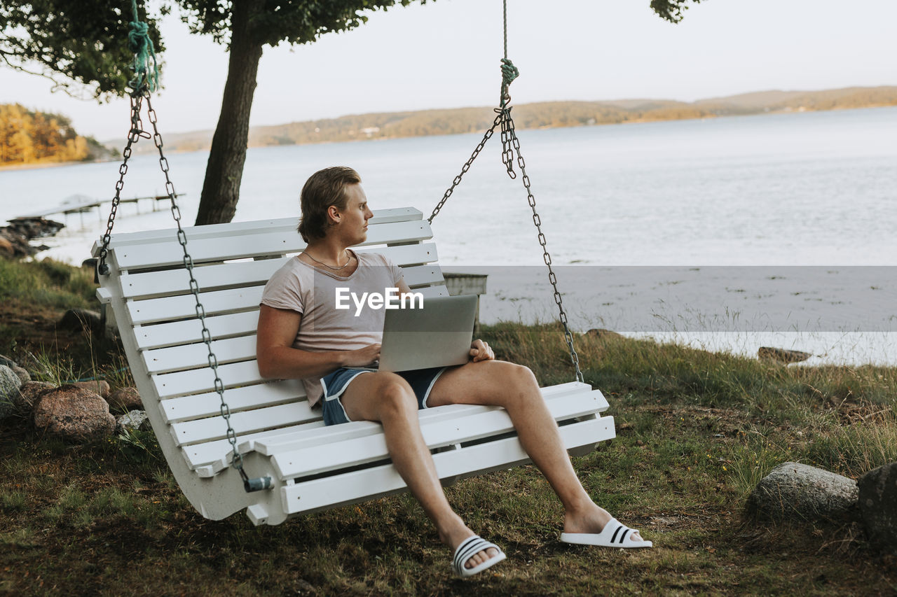 Man on garden swing looking away