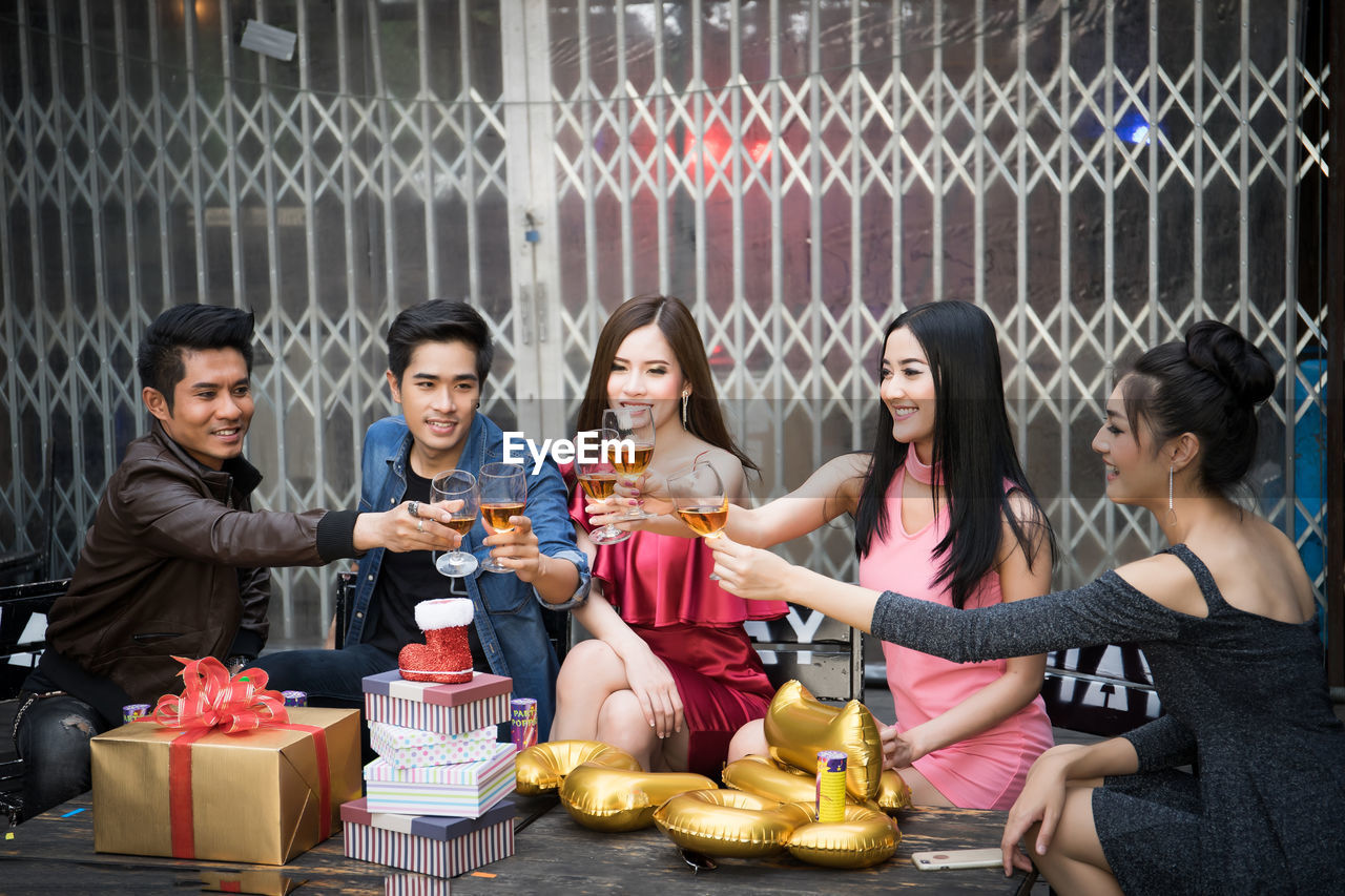 Friends toasting drinks during party