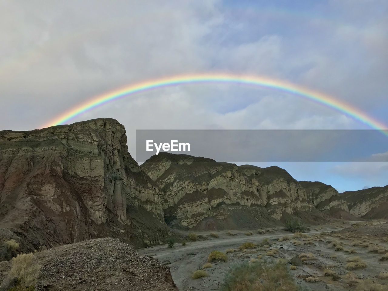 RAINBOW OVER MOUNTAIN AGAINST SKY