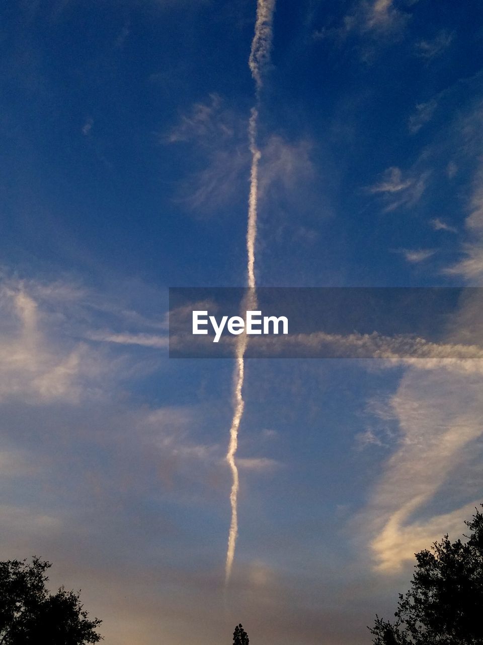 LOW ANGLE VIEW OF VAPOR TRAIL AGAINST BLUE SKY