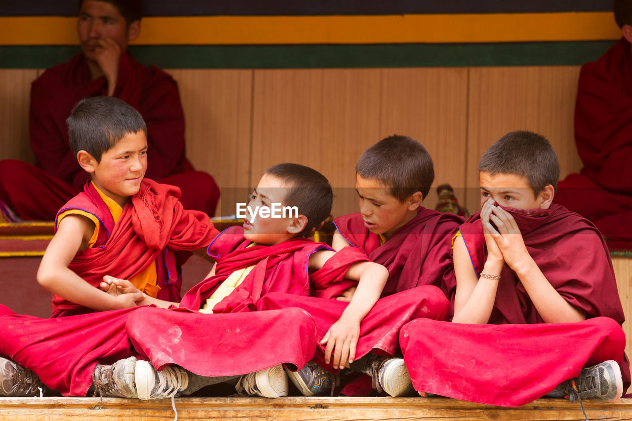 HIGH ANGLE VIEW OF PEOPLE LOOKING AT TRADITIONAL CLOTHING SITTING