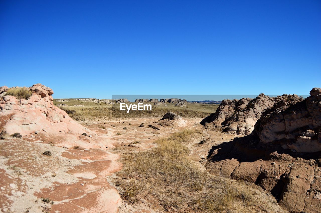 SCENIC VIEW OF ROCKS AGAINST CLEAR BLUE SKY