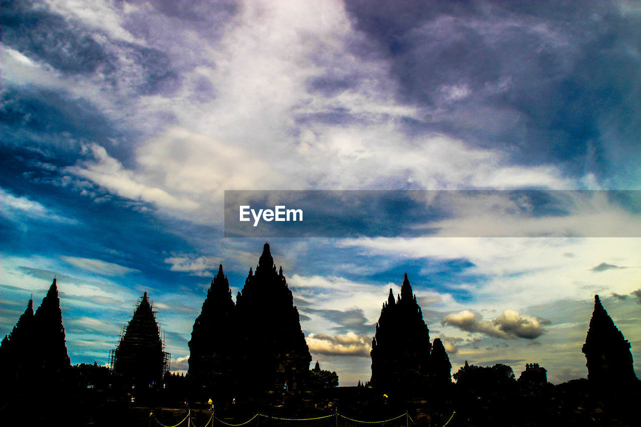 HIGH SECTION OF SILHOUETTE BUILDINGS AGAINST CLOUDY SKY