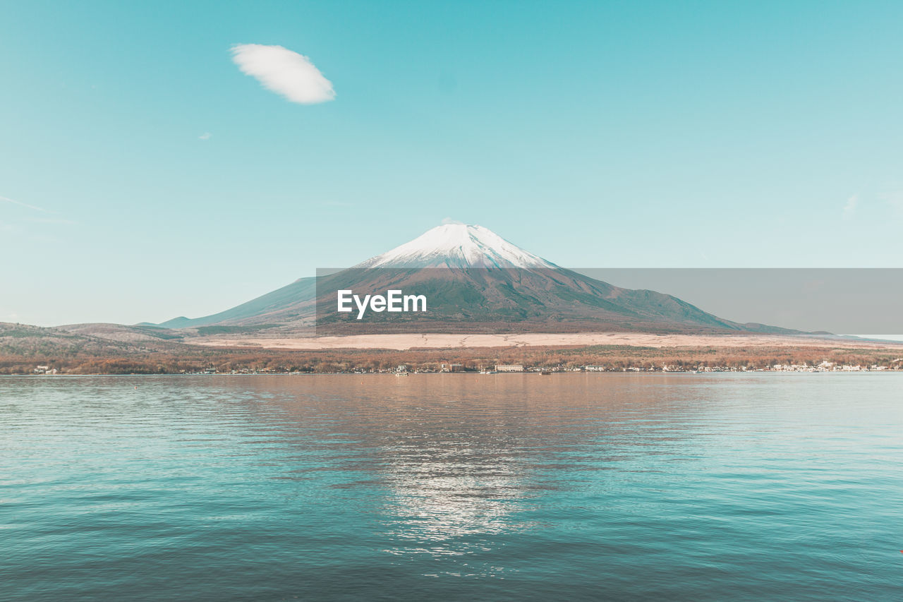 Scenic view of lake and mountains against blue sky