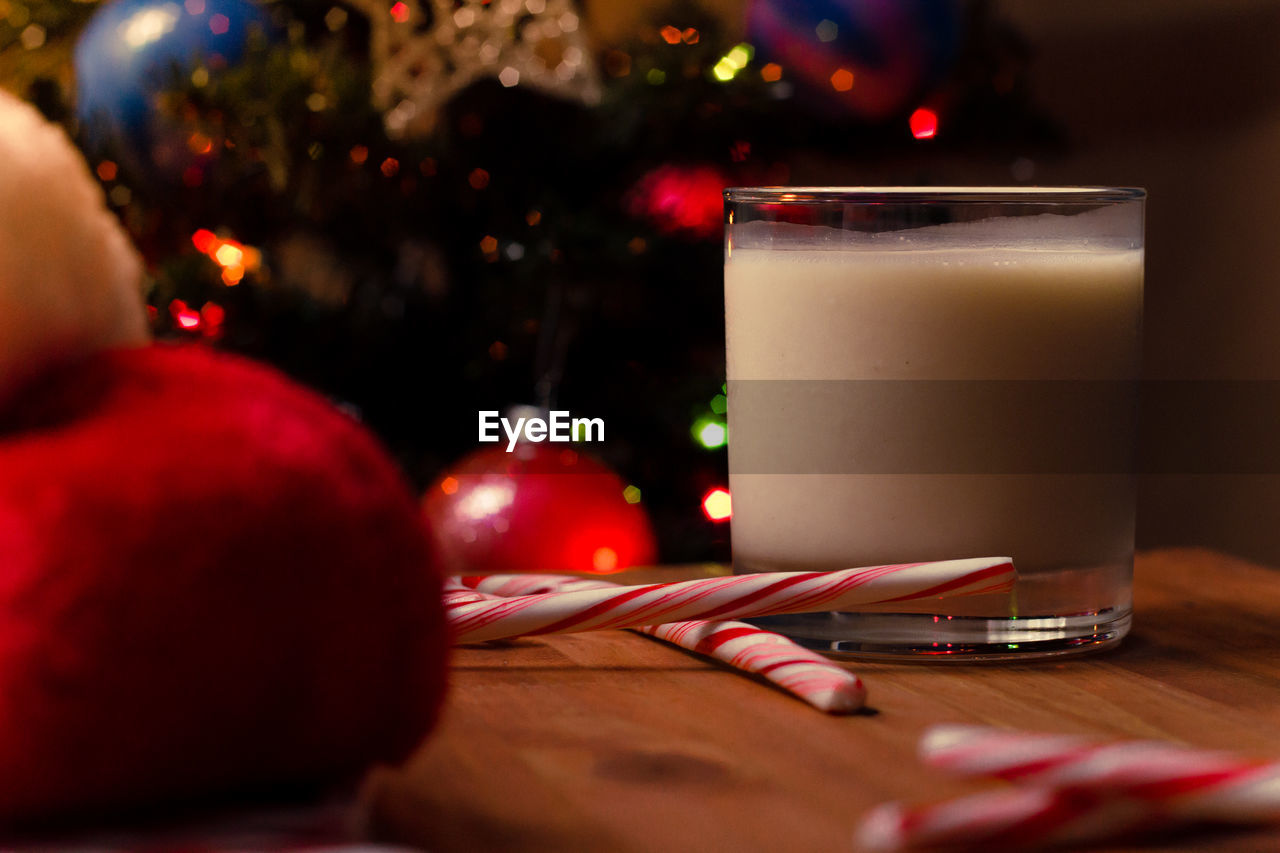 Close-up of drink by candy canes in glass on table