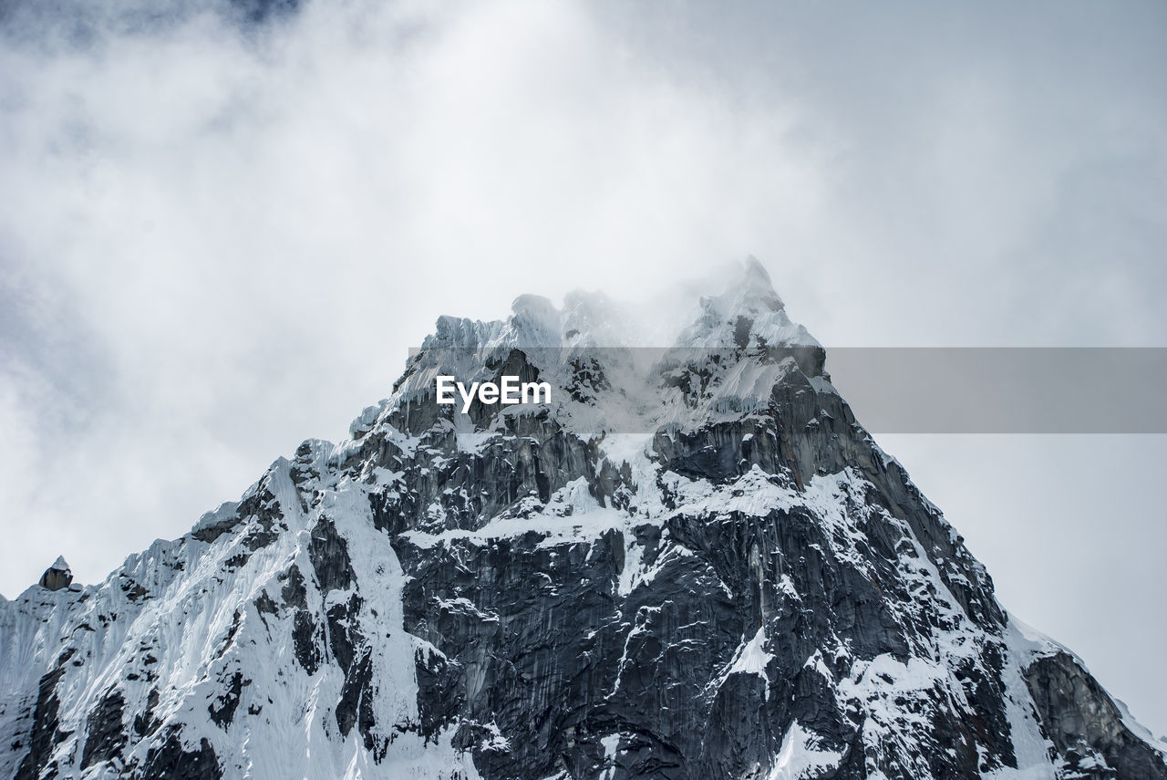 Low angle view of snowcapped mountain against sky