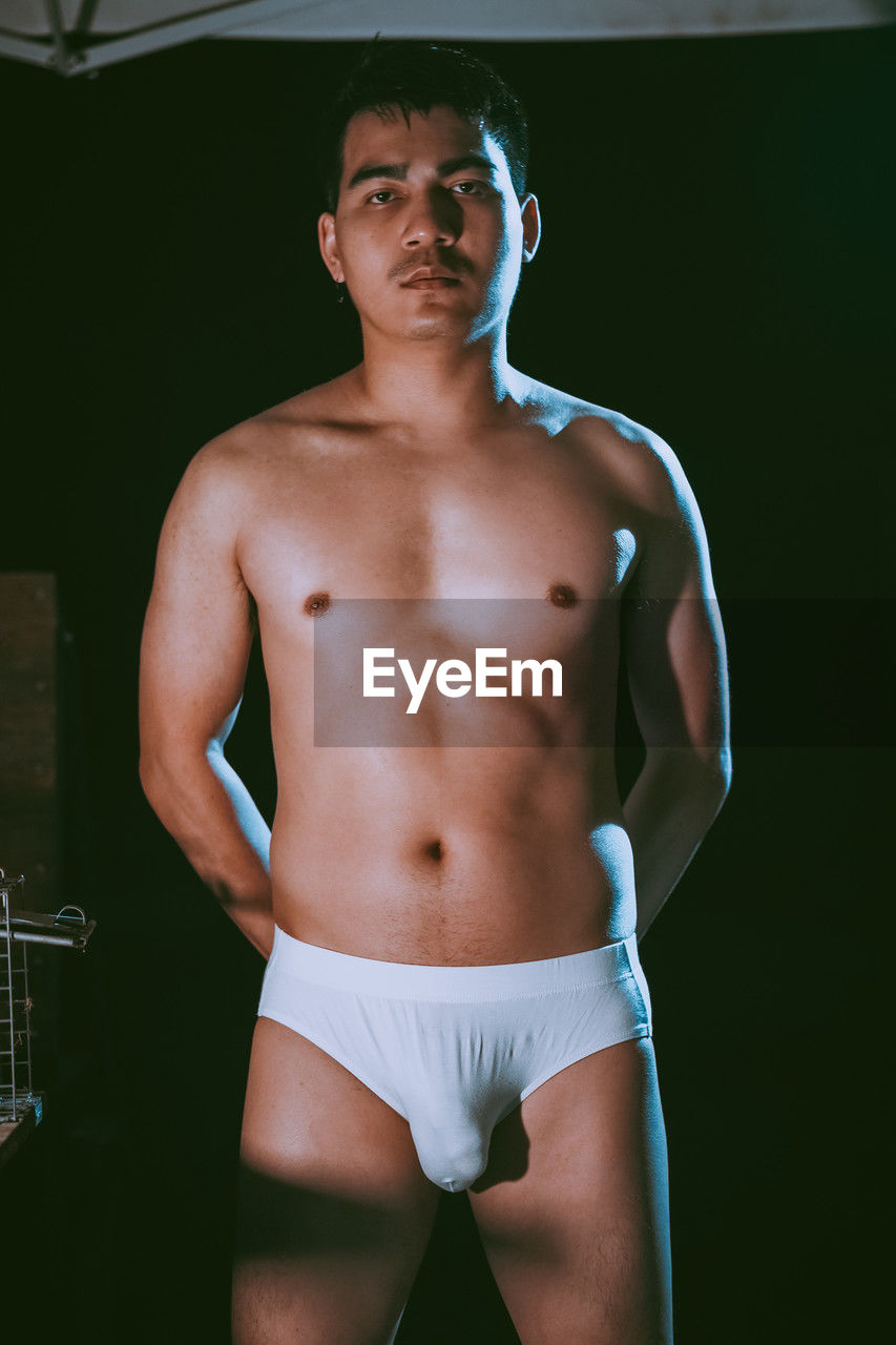 briefs, one person, barechested, adult, men, underpants, portrait, young adult, muscular build, standing, sports, athlete, undergarment, clothing, strength, lifestyles, exercising, three quarter length, looking at camera, indoors, front view, serious, person, looking, player, sports training, arm, waist up, sports clothing