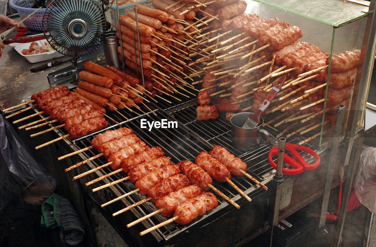 Grilled pork sausage on charcoal. nem nuong ninh hoa on street of hi chi minh city, viet nam.