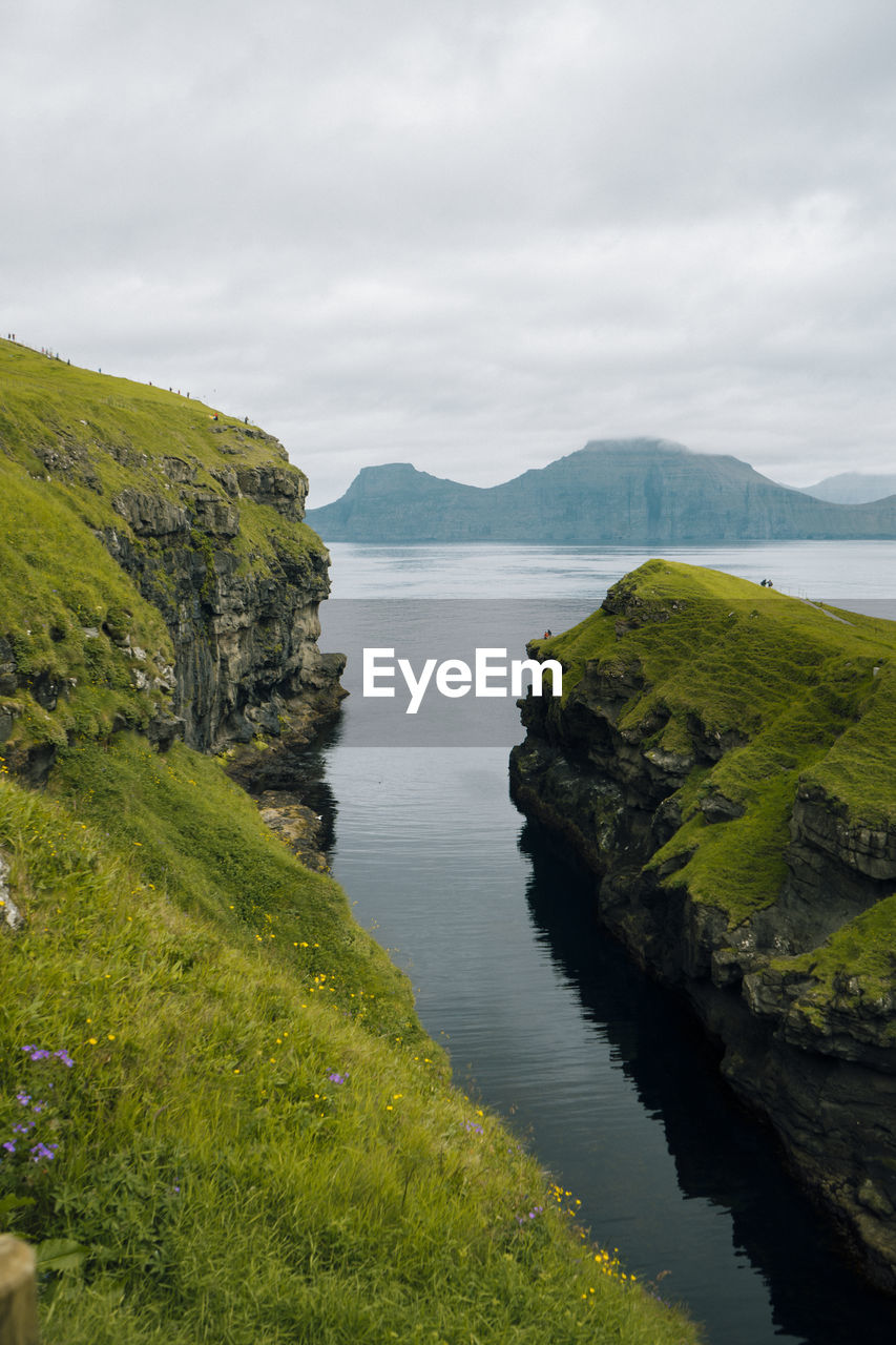 Scenic view of land and mountains against sky