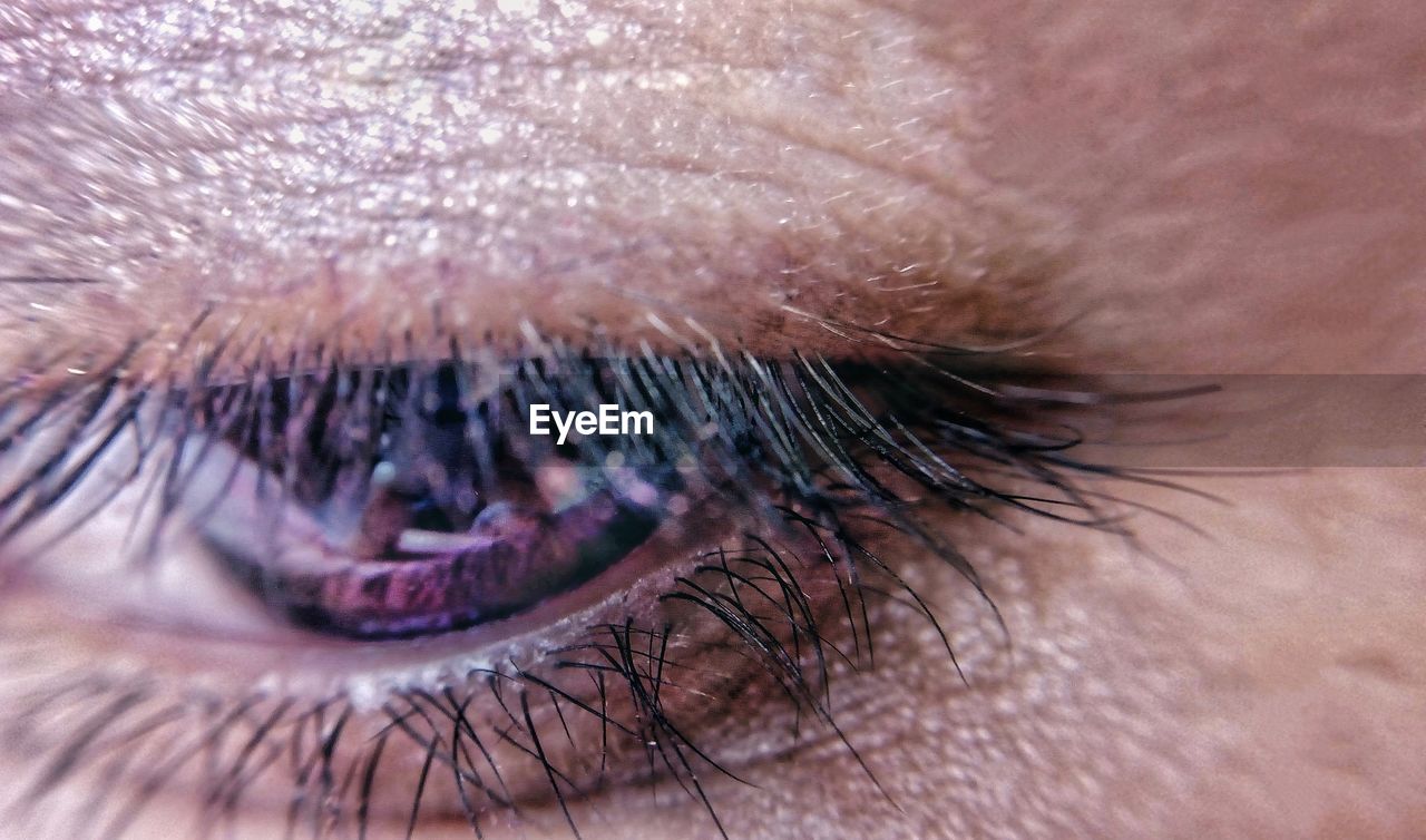 EXTREME CLOSE-UP OF WOMAN EYE WITH HANDS