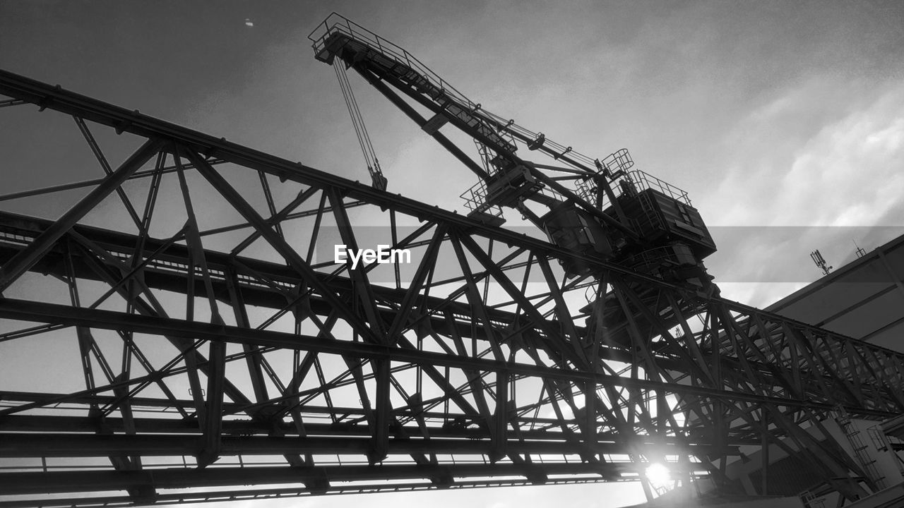 LOW ANGLE VIEW OF CRANES AGAINST SKY