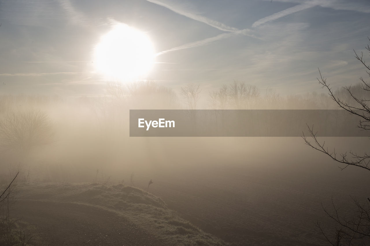 Scenic view of landscape against bright sun