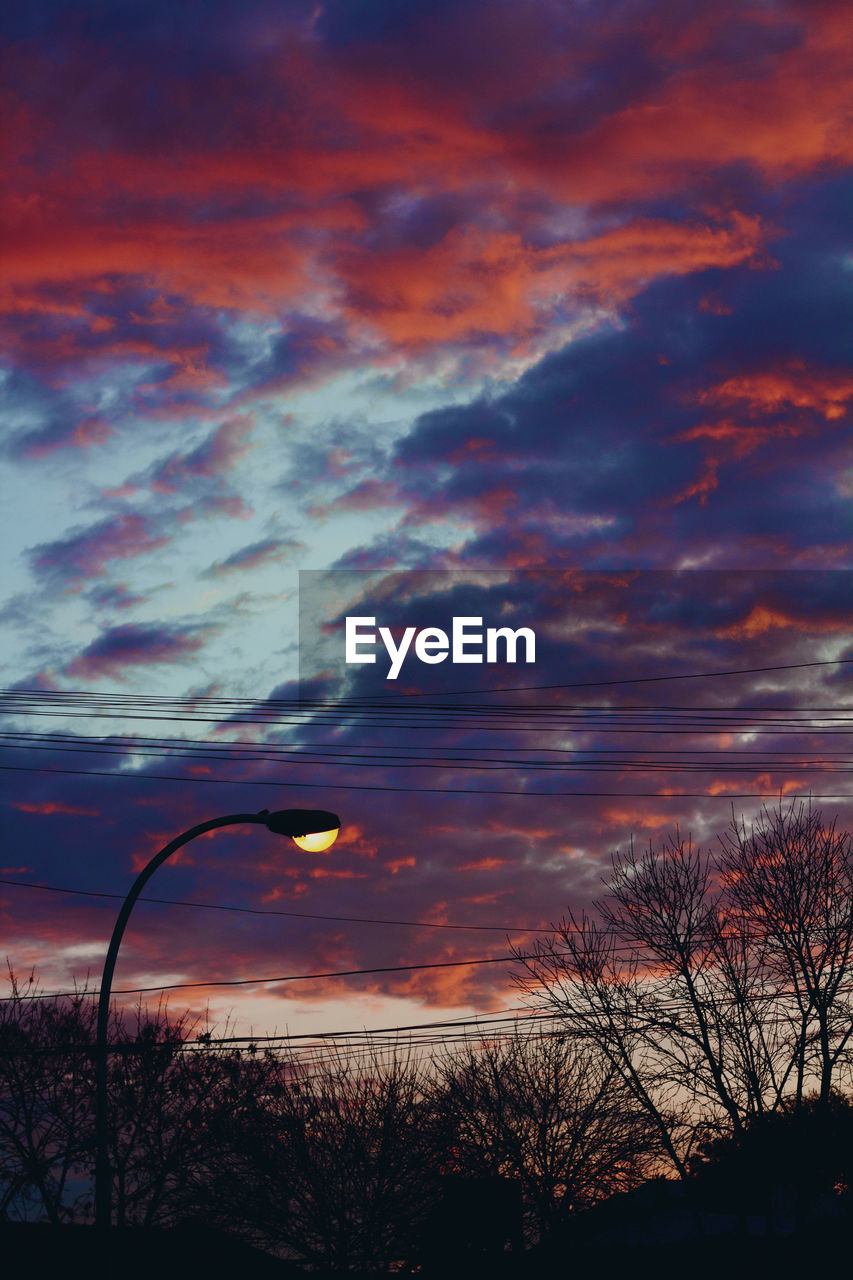 SCENIC VIEW OF SKY OVER SILHOUETTE BARE TREES AGAINST SUNSET