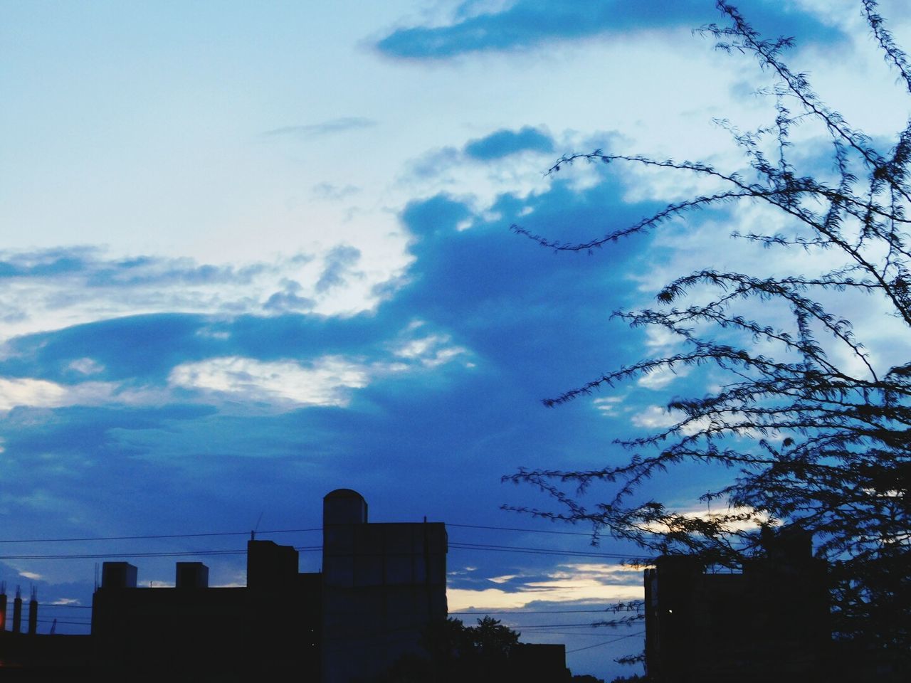 LOW ANGLE VIEW OF SILHOUETTE SKYSCRAPERS AGAINST SKY