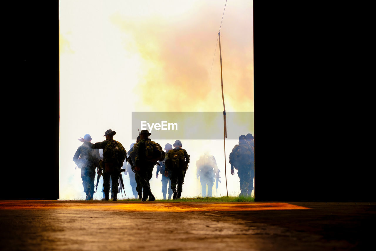 REAR VIEW OF PEOPLE WALKING AGAINST SKY