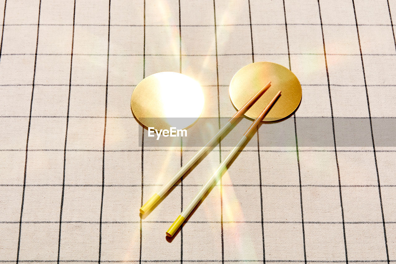 Two golden coasters with chopsticks