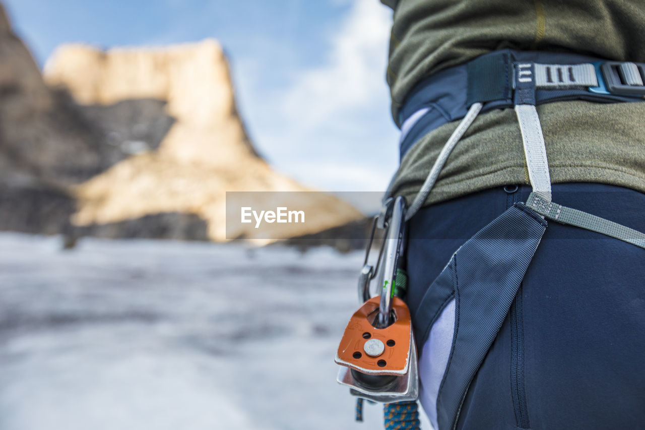 Detail view of climber harness with pulleys clipped on.