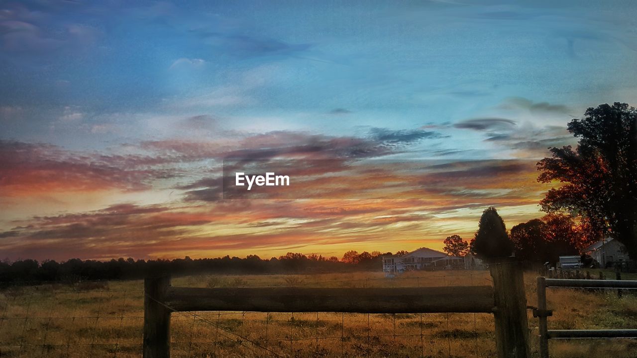 SCENIC VIEW OF SUNSET OVER FIELD