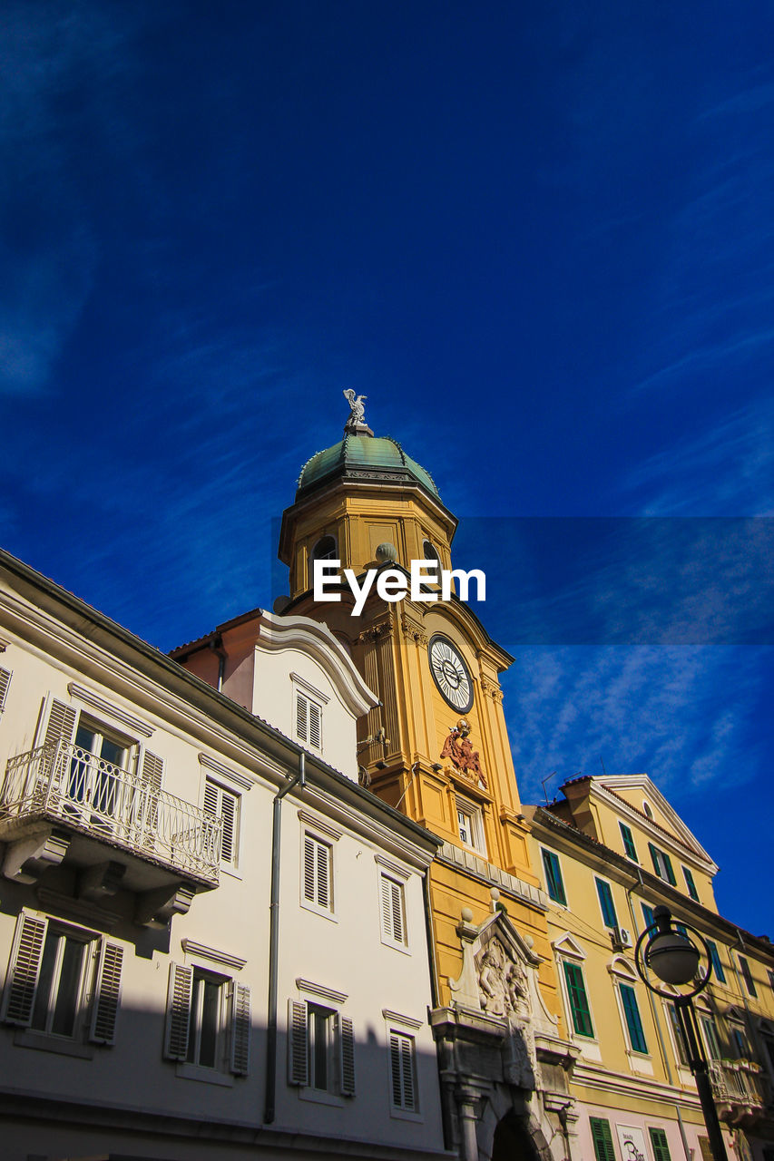 Low angle view of building in rijeka against blue sky