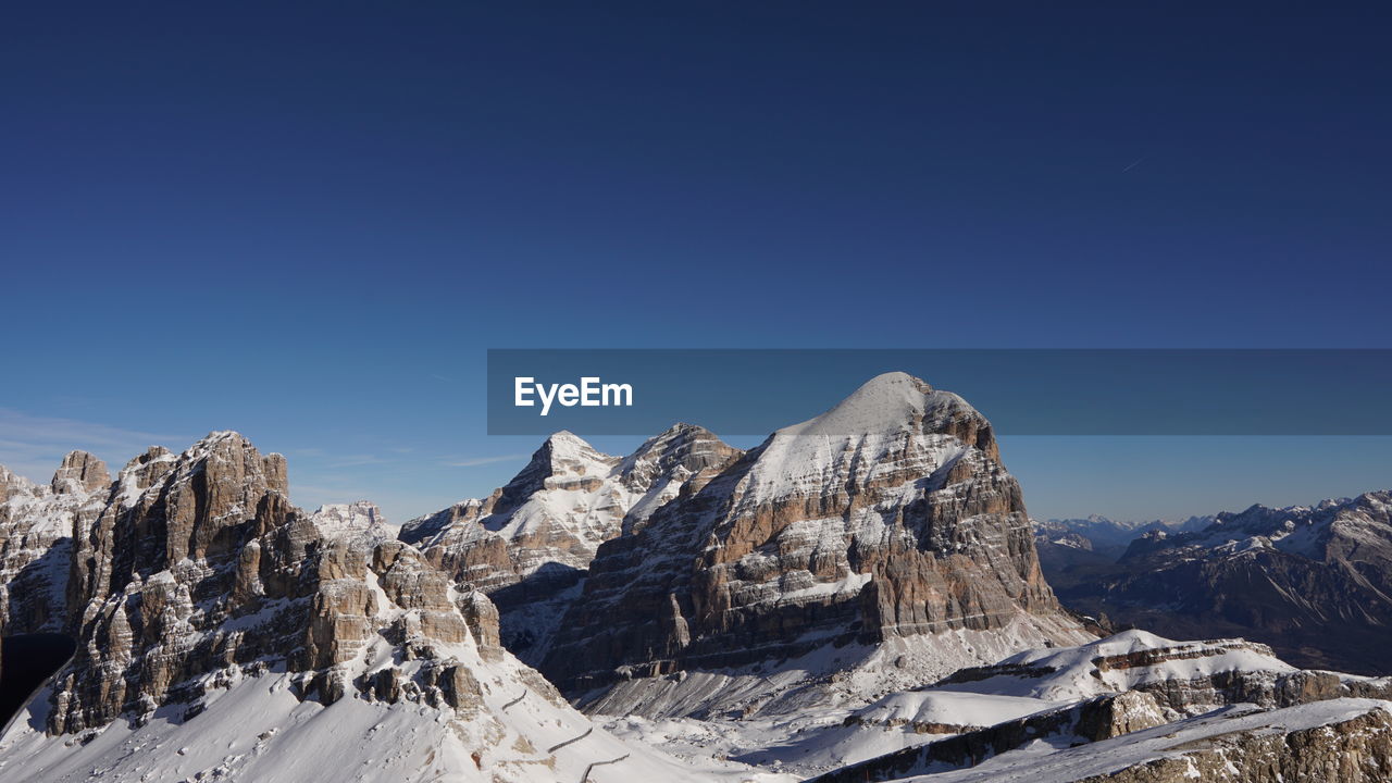 Scenic view of snowcapped mountains against clear blue sky