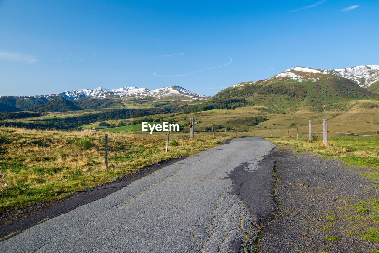 Road amidst landscape against blue sky