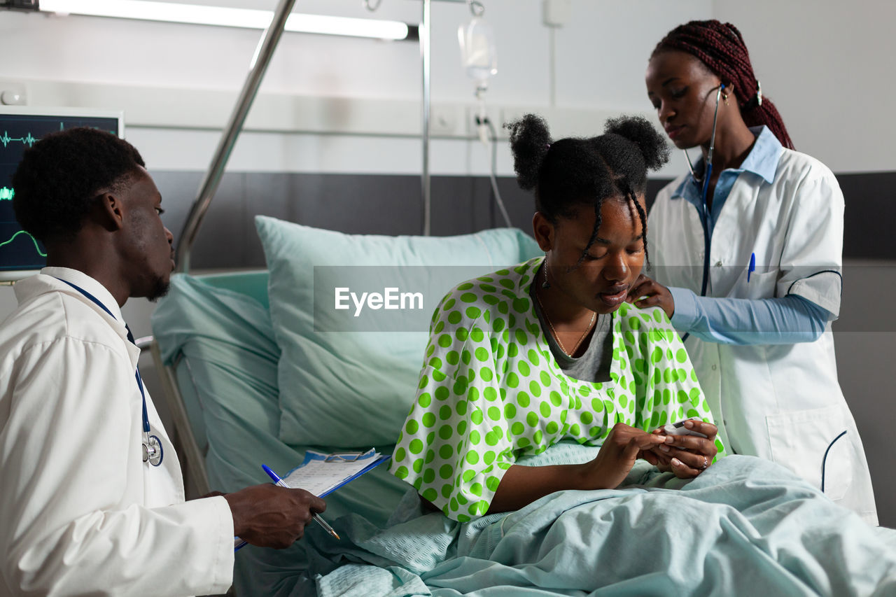 Doctors examining patient in clinic