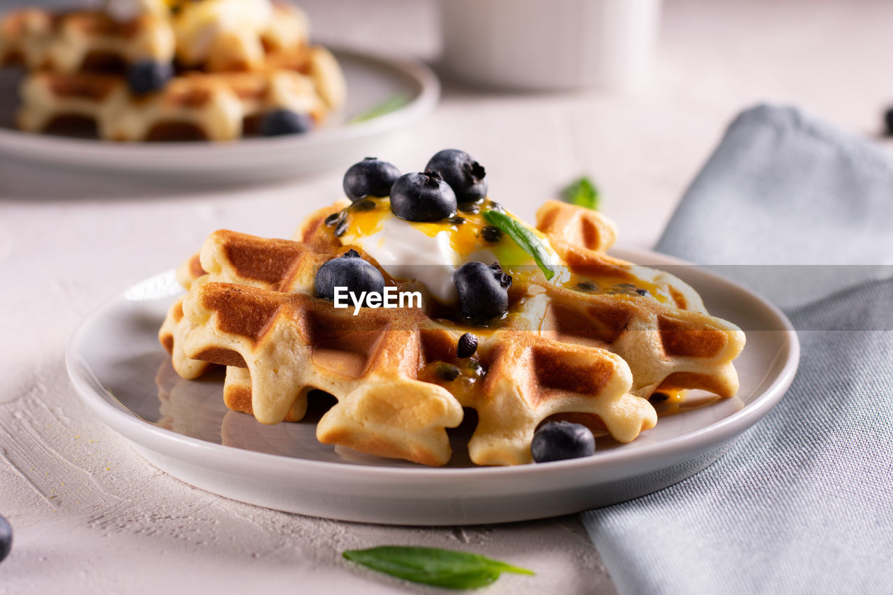 Breakfast with waffles with blueberries and syrup on a plates