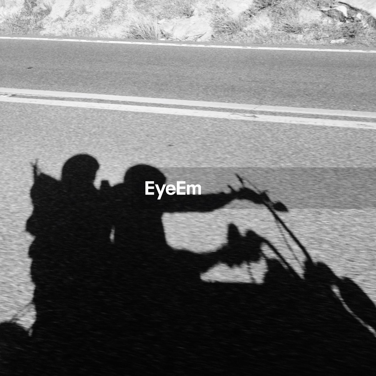 Shadow of people riding motorcycle