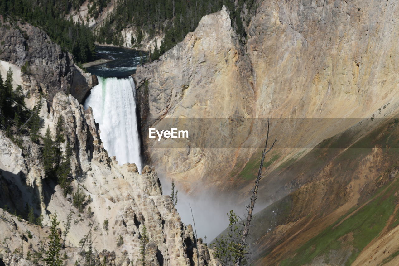 SCENIC VIEW OF WATERFALL IN MOUNTAINS