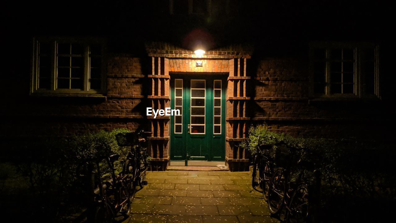 Illuminated path by building at night