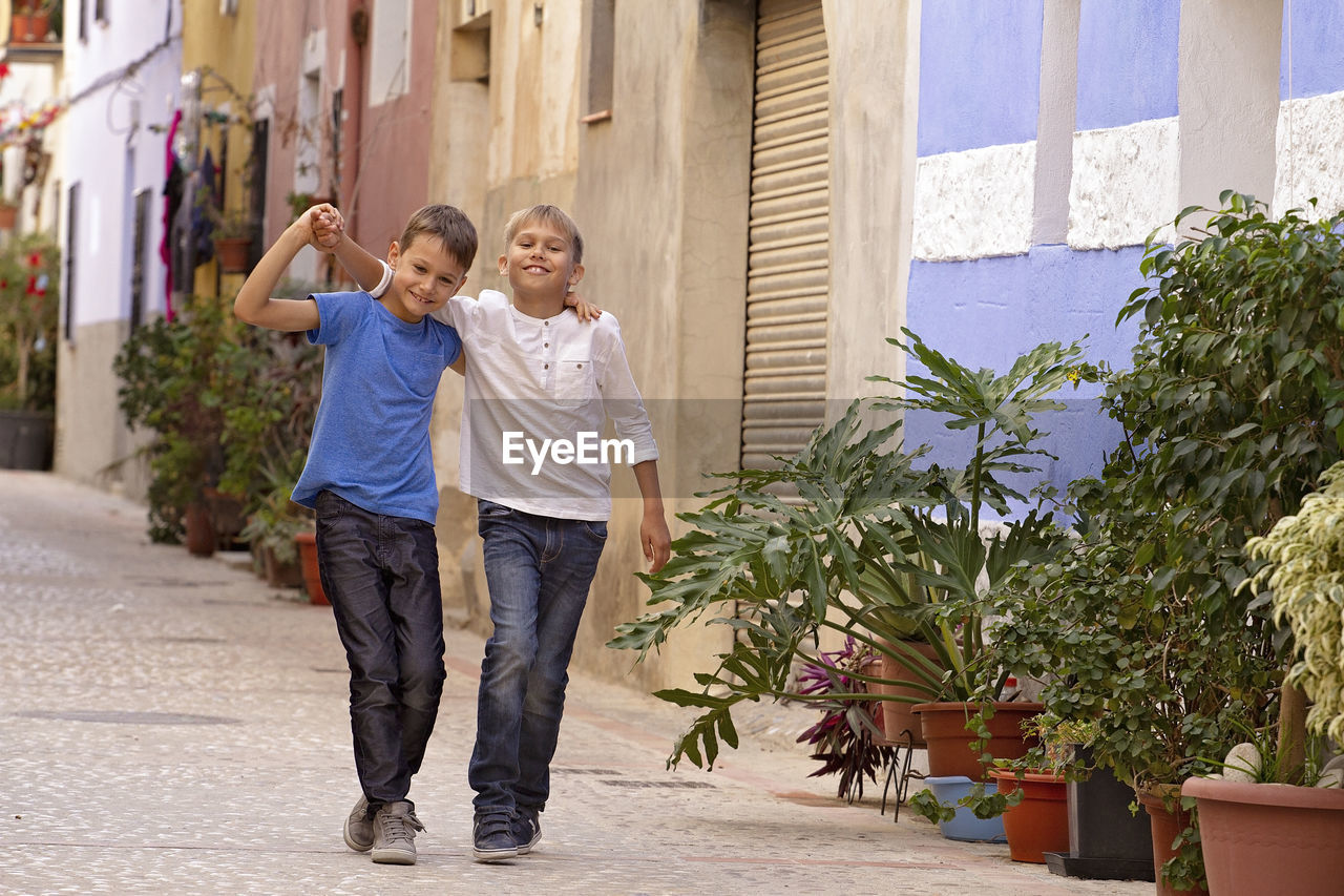 Two happy kids outdoors in the street european city on summer day