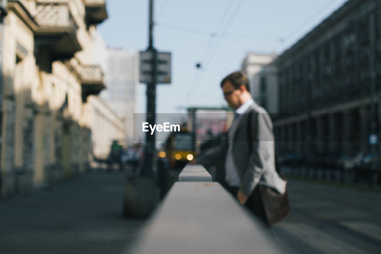 SIDE VIEW OF MAN WALKING ON ROAD