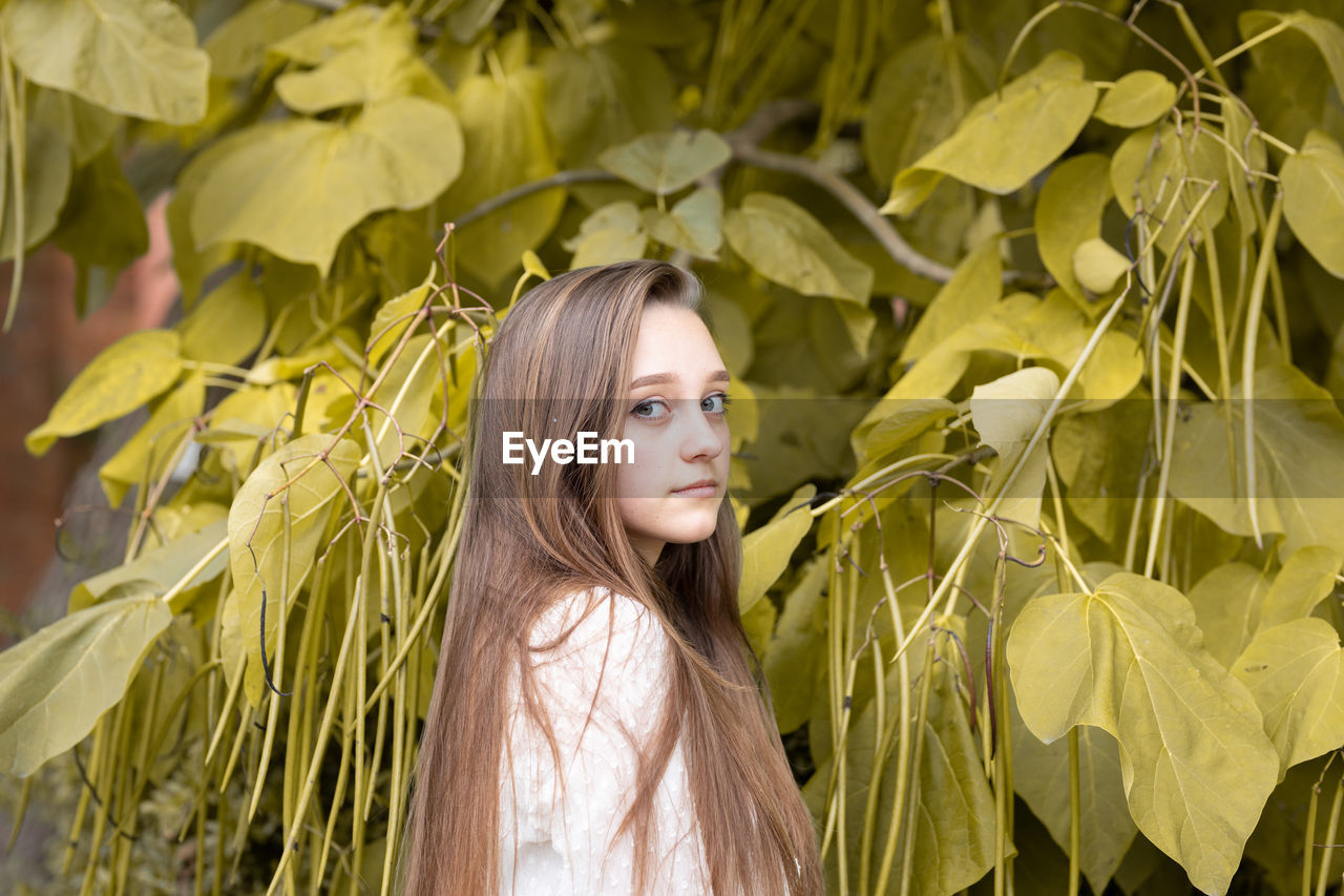 Portrait of woman standing by plants