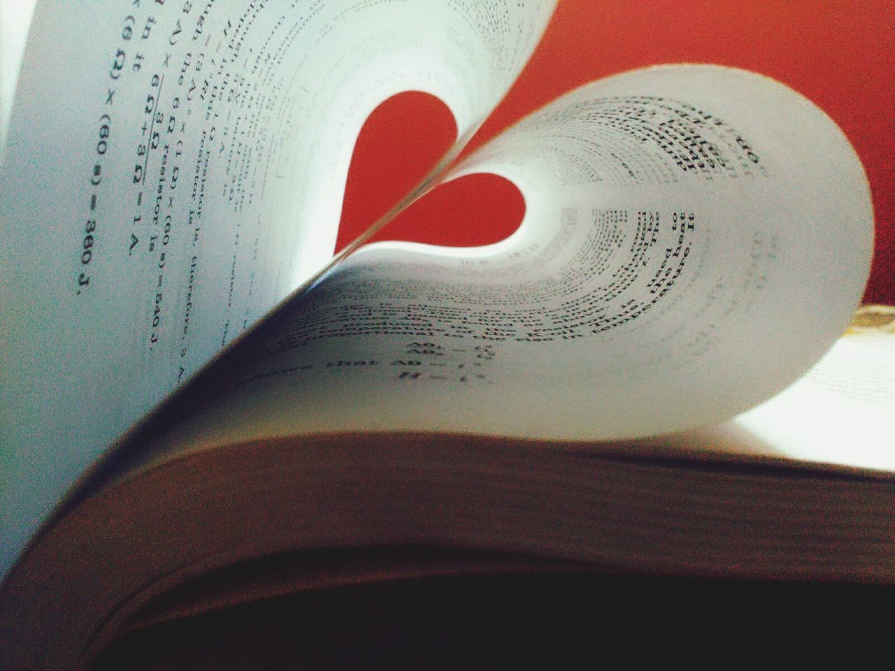 Close-up of papers with heart shape on book