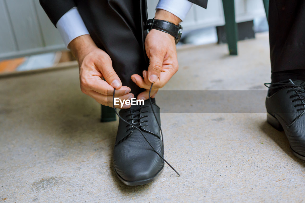 Low section of man tying shoes