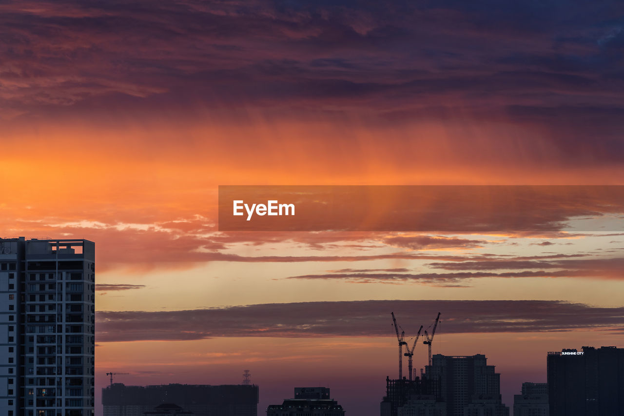 SILHOUETTE BUILDINGS AGAINST ORANGE SKY