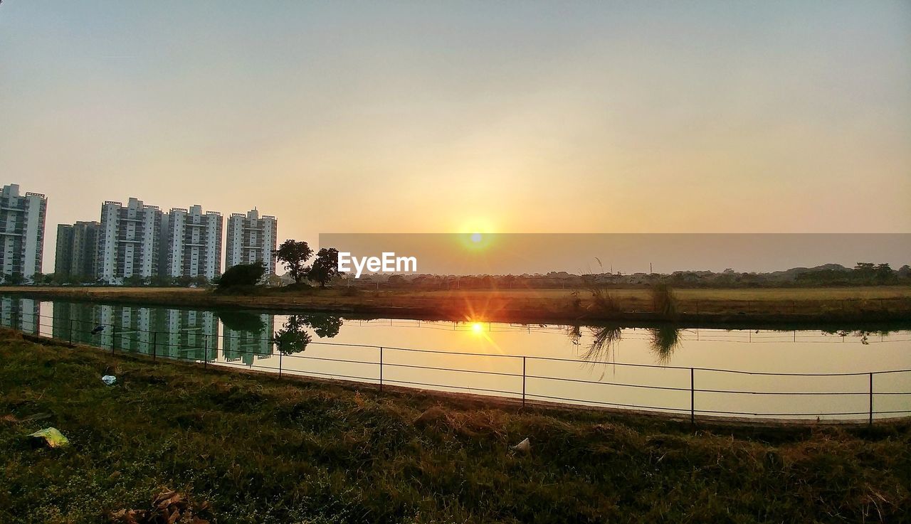 Scenic view of lake against clear sky during sunset