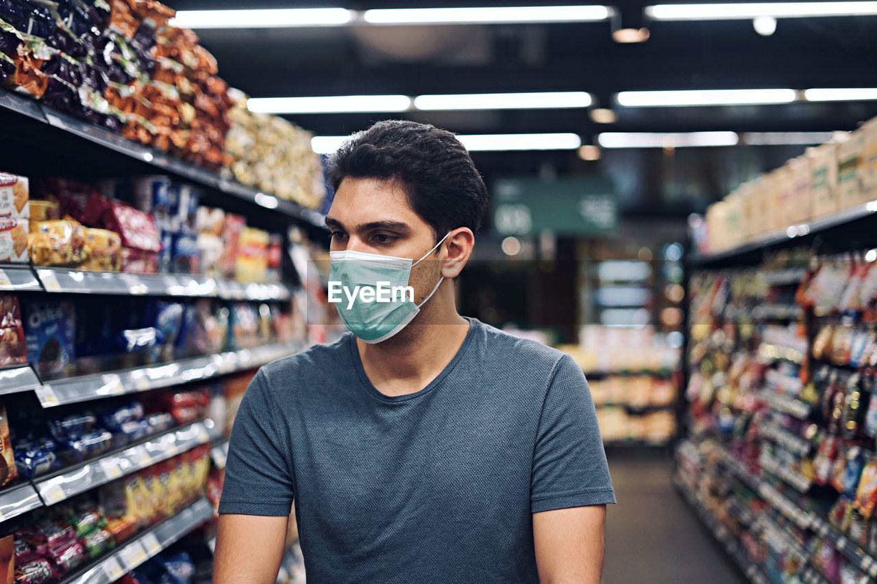 Portrait of young man standing in store