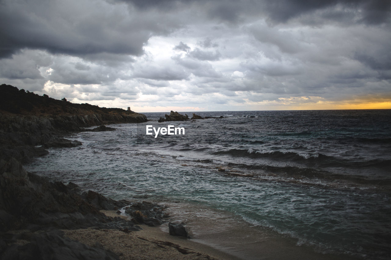 SCENIC VIEW OF BEACH AND SEA AGAINST CLOUDY SKY