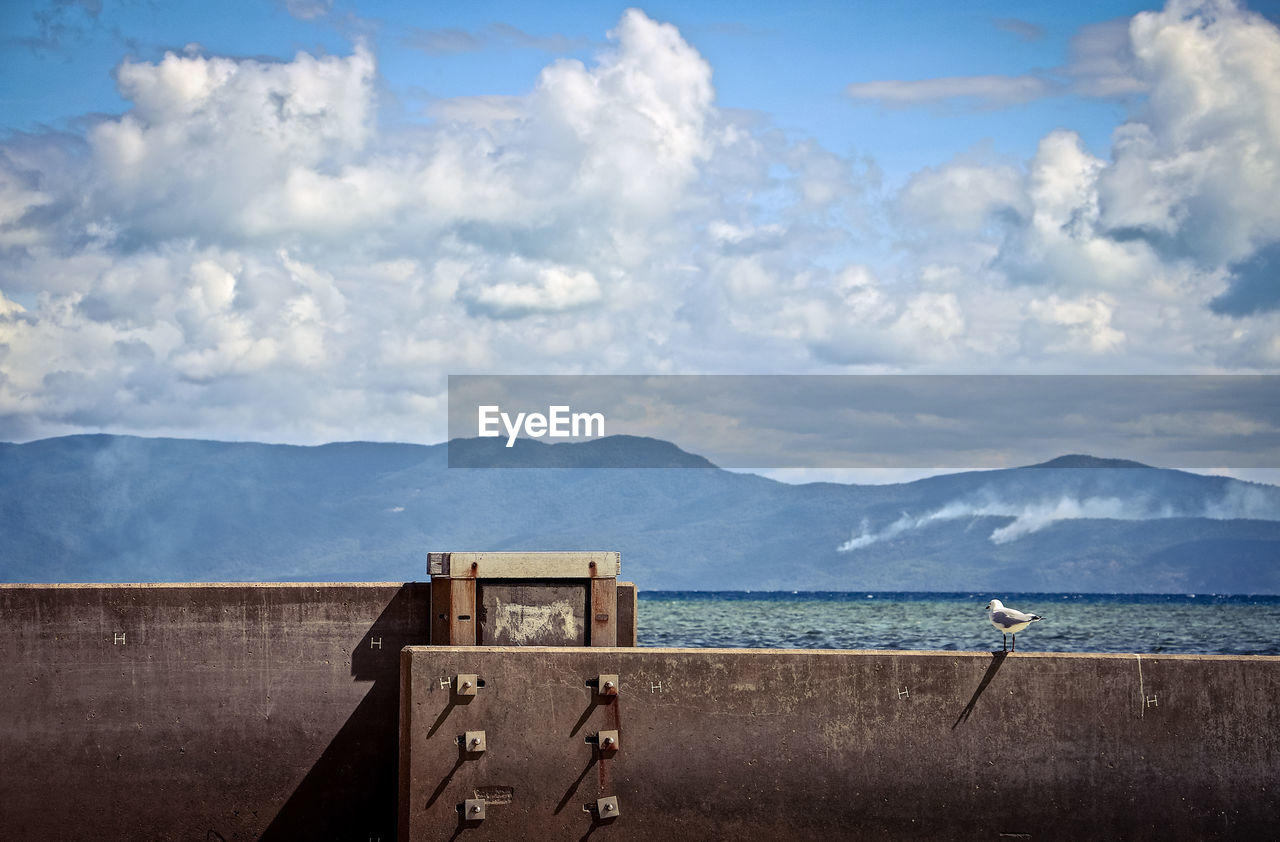 SCENIC VIEW OF SEA AGAINST MOUNTAINS