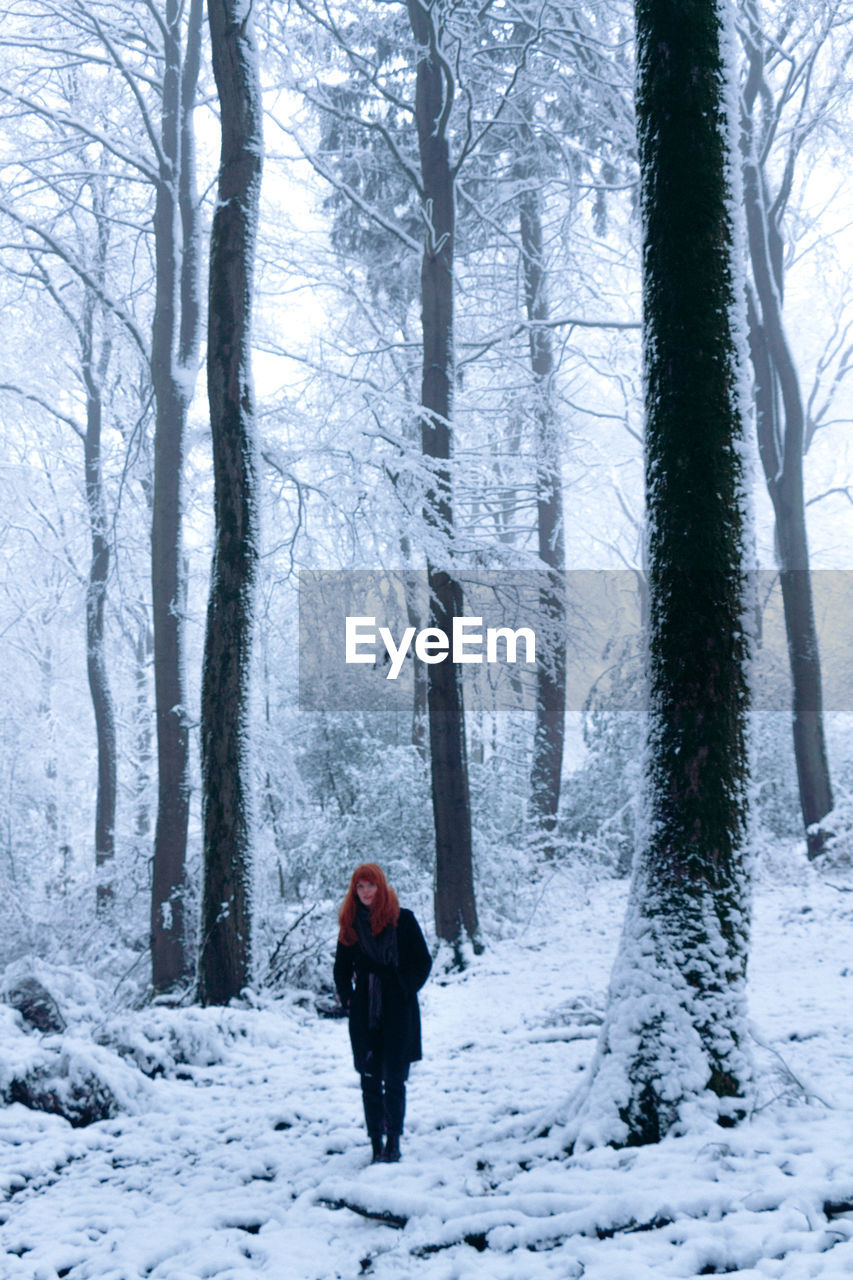 Rear view of woman walking on snow covered landscape