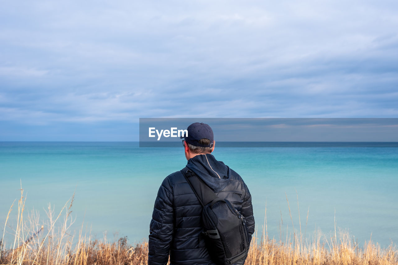 Man standing by sea against sky