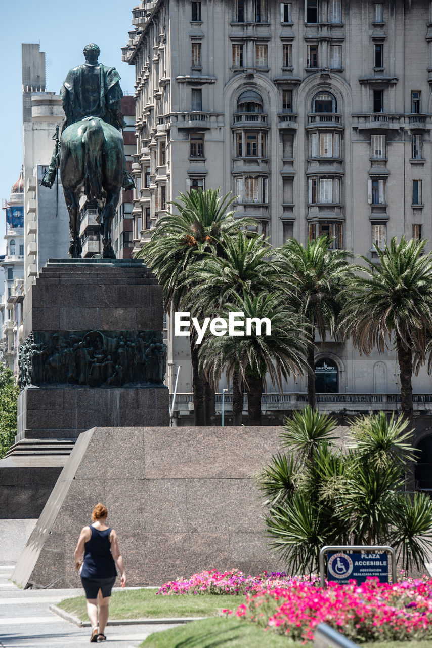 STATUE AGAINST TREES AND BUILDINGS