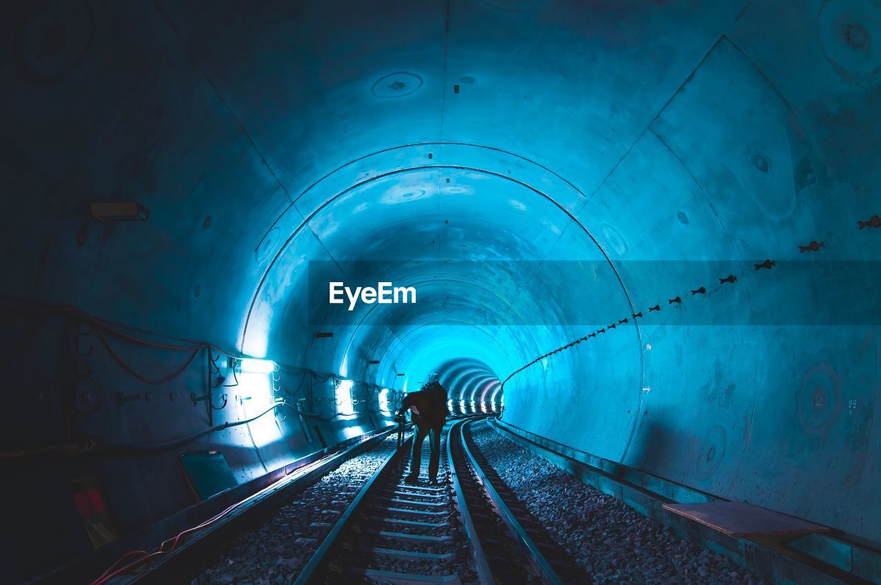 Man standing in illuminated tunnel