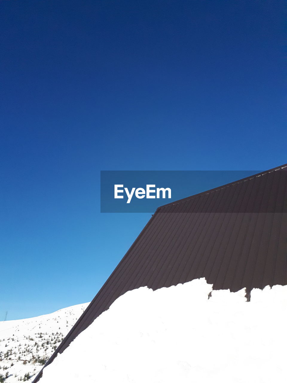 LOW ANGLE VIEW OF ROOF AGAINST CLEAR SKY DURING WINTER