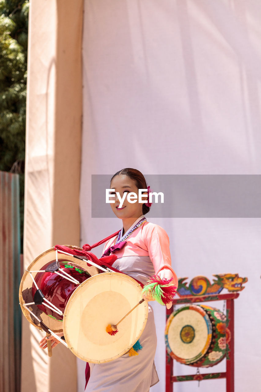 HAPPY YOUNG WOMAN PLAYING WITH BALL IN BACKGROUND