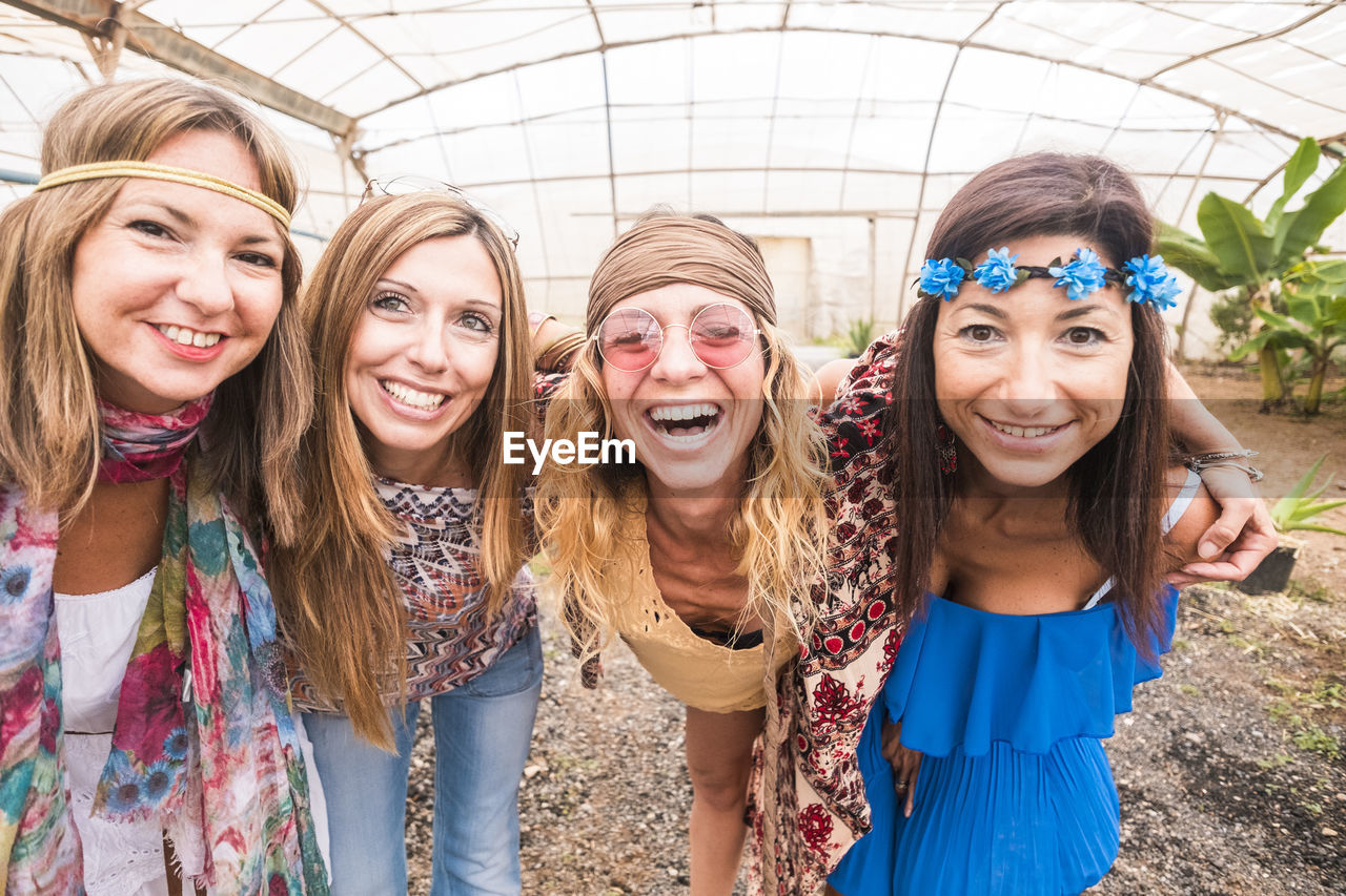 Portrait of smiling friends in greenhouse